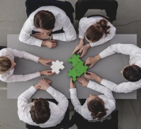 Group of business people assembling jigsaw puzzle and represent team support and help concept