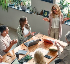Multiracial creative people in modern office. Group of young business people and senior boss are working together with laptop, tablet, smart phone, notebook, graphs. Successful team in coworking
